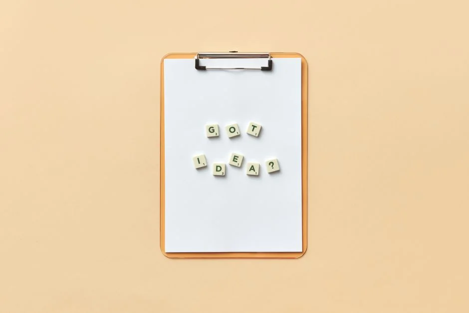 Flat lay of keyboard letter tiles spelling email on coral backdrop.